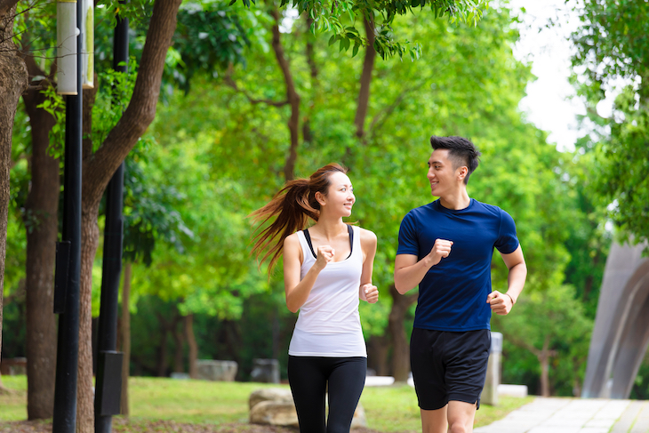 Happy couple jogging in park